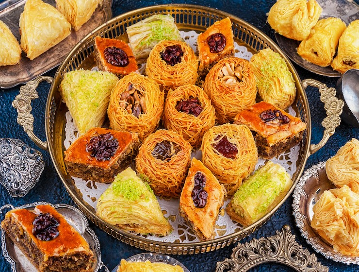 Assorted traditional Turkish desserts including baklava and kadayif displayed on a decorative tray